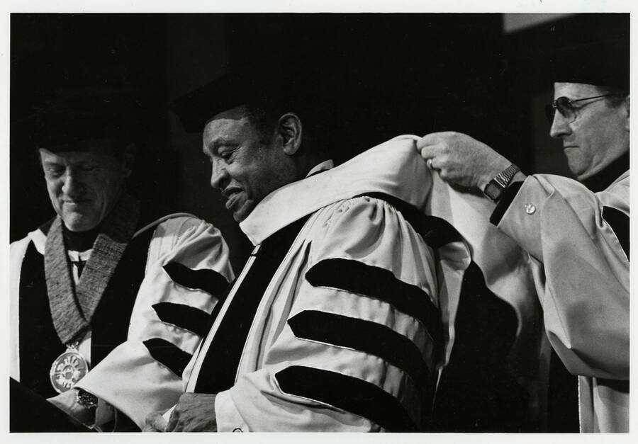 10" x 8" black and white photograph. Lionel Hampton being hooded for his honorary doctorate from the University of Idaho. President Richard D. Gibb sits in the background.