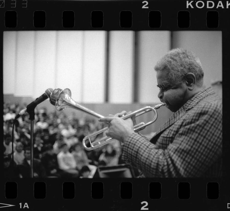 1.5" x 1" black and white print. One of thirty images found on a contact sheet. Dizzy Gillespie playing trumpet into microphone during his jazz clinic.