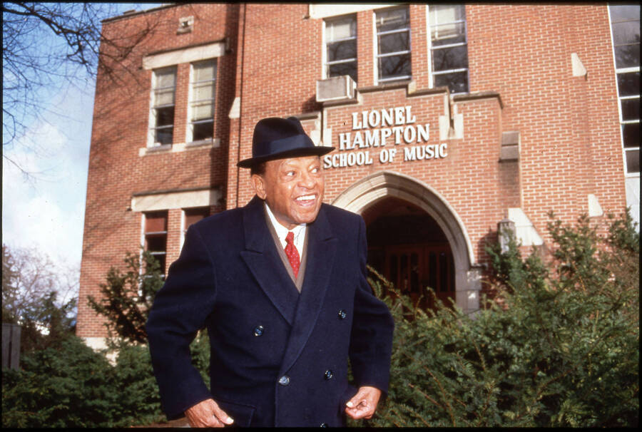 35mm color slide. Lionel Hampton standing in front of the Lionel Hampton School of Music.