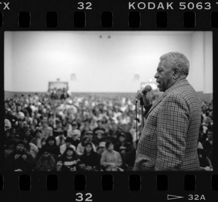 1.5" x 1" black and white print. One of thirty images found on a contact sheet. Dizzy Gillespie speaking into microphone to audience during his jazz clinic.