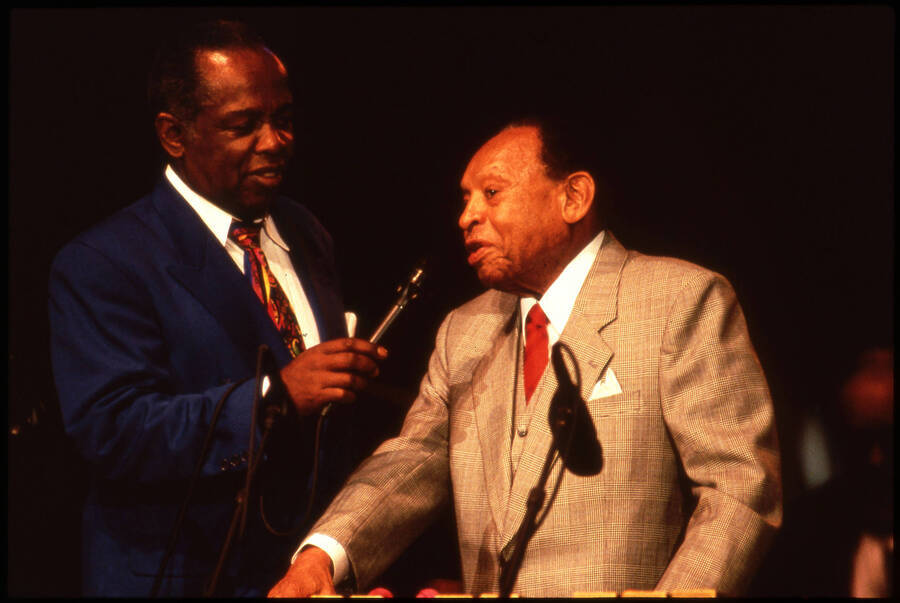35mm color slide. Lou Rawls holds a microphone for Lionel Hampton at the 1997 Lionel Hampton Jazz Festival.