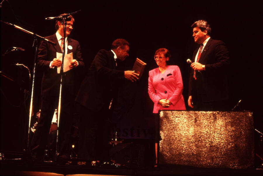 35 mm color slide. Lionel Hampton and Lynn "Doc" Skinner present two unidentified individuals a plaque on stage at the Pepsi International World Jazz Night at the 1992 Lionel Hampton-Chevron Jazz Festival.