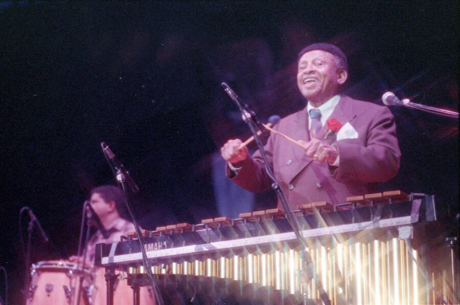 35mm color negative. Lionel Hampton playing the vibes with Gabriel Machado playing conga in the background at the 1991 Lionel Hampton-Chevron Jazz Festival.