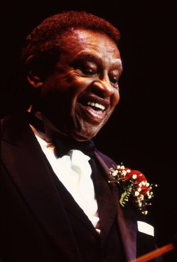 35 mm color slide. Lionel Hampton wearing a red carnation smiles and looks down at the Pepsi International World Jazz Night