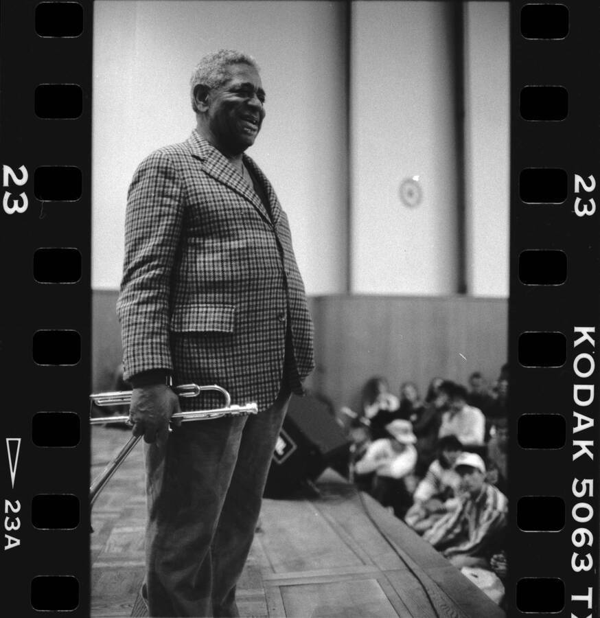 1" x 1.5" black and white print. One of thirty images found on a contact sheet. Dizzy Gillespie stands on stage during his jazz clinic.