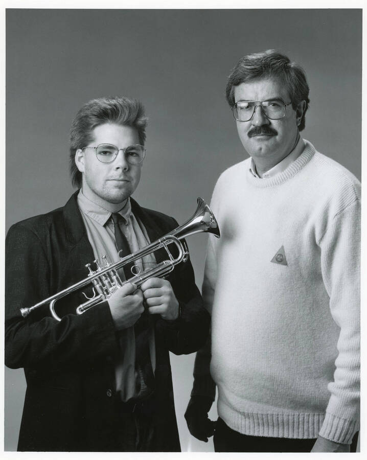 8" x 10" black and white photograph. Lynn "Doc" Skinner standing with John Fricke who is holding a trumpet.