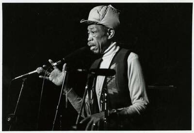 7" x 5" black and white photograph. Al Grey speaks into microphone at the Lionel Hampton Jazz Festival.
