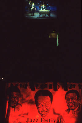35mm color slide. Lionel Hampton and Lembit Saarsalu shown on a video monitor above the stage at the Pepsi International World Jazz Night at the 1992 Lionel Hampton-Chevron Jazz Festival.