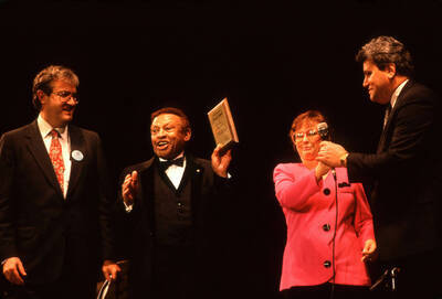 35 mm color slide. Lionel Hampton and Lynn "Doc" Skinner present two unidentified individuals a plaque on stage at the Pepsi International World Jazz Night at the 1992 Lionel Hampton-Chevron Jazz Festival.