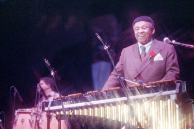 35mm color negative. Lionel Hampton playing the vibes with Gabriel Machado playing conga in the background at the 1991 Lionel Hampton-Chevron Jazz Festival.