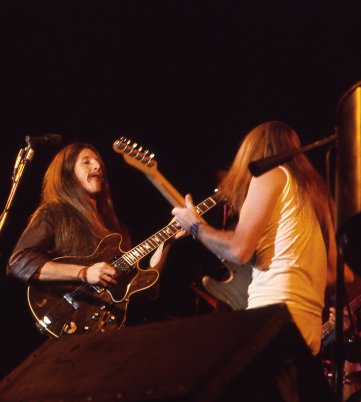 Color photograph of two men playing guitars.