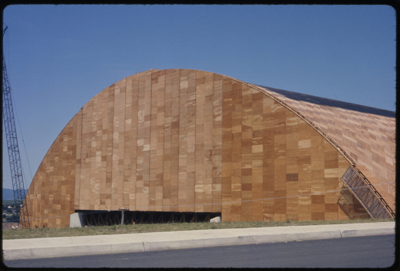 Color photograph of an arched wooden building under construction.