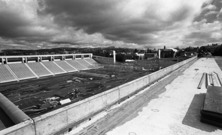 Black and white photograph of an open air stadium with concrete stands.