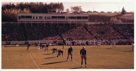 Color photograph of a football game held in an open air stadium.