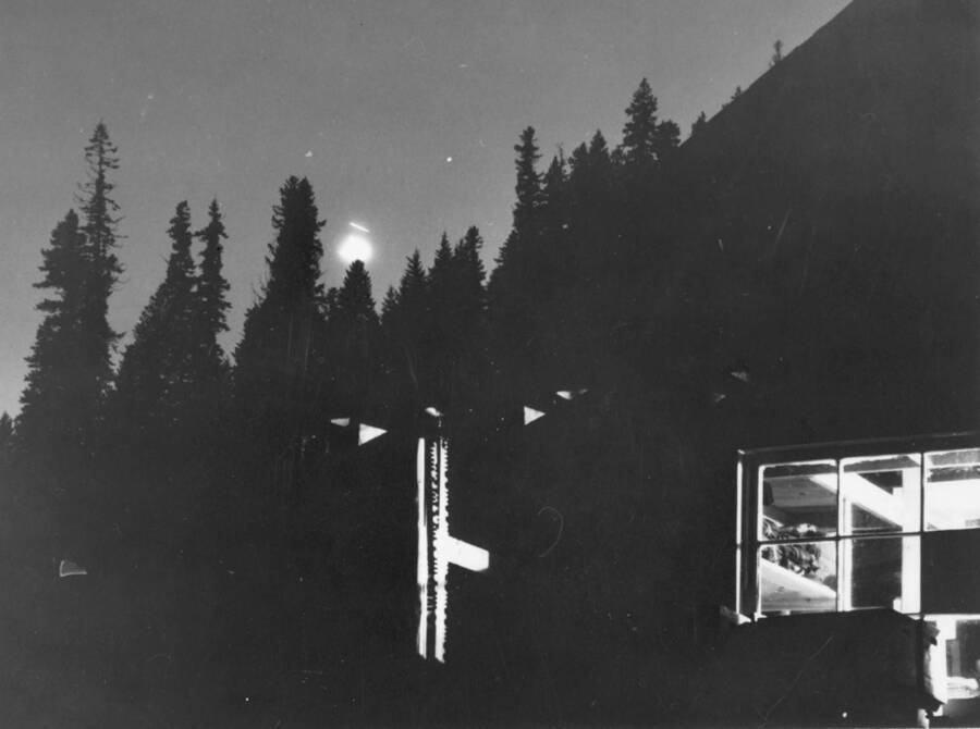 Image taken during night at Kooskia Internment Camp of building with lights. Photo taken from 12-3/4 x 15-1/4 Photograph album of the Kooskia Japanese Internment Camp.