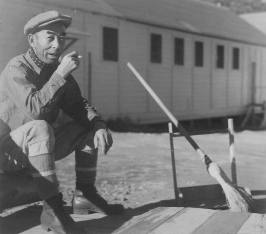 Image of man at Kooskia Internment Camp sitting with cigarette. Photo taken from 12-3/4 x 15-1/4 Photograph album of the Kooskia Japanese Internment Camp.