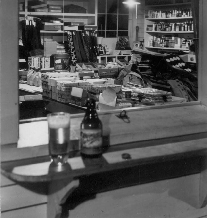 Interior image of store merchandise in back room from a window at the front counter at Kooskia Internment Camp. Photo taken from 12-3/4 x 15-1/4 Photograph album of the Kooskia Japanese Internment Camp.