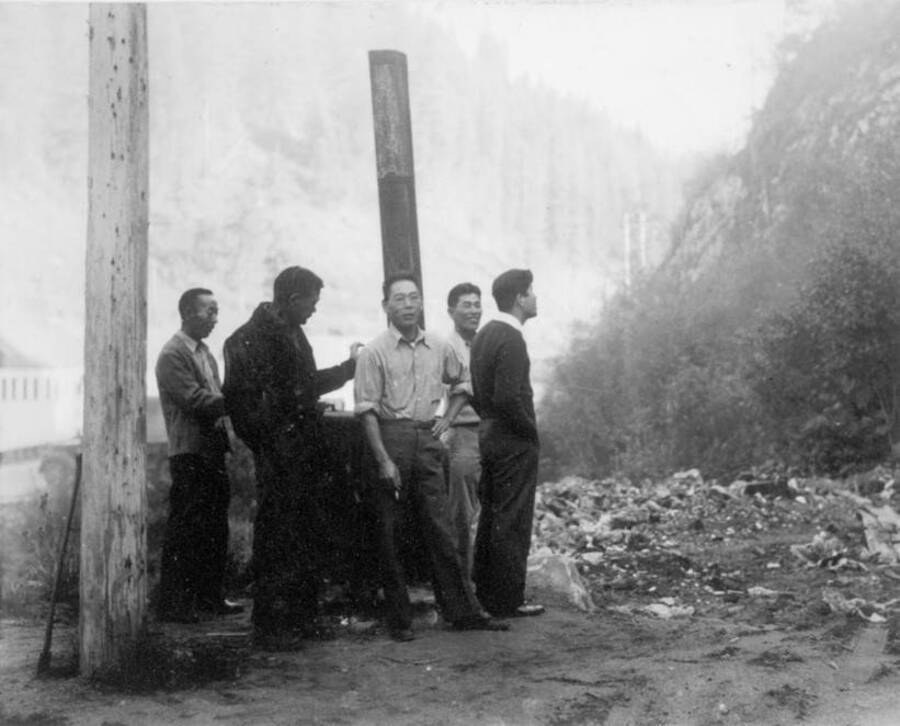 Image of men standing outside at Kooskia Internment Camp. Photo taken from 12-3/4 x 15-1/4 Photograph album of the Kooskia Japanese Internment Camp.