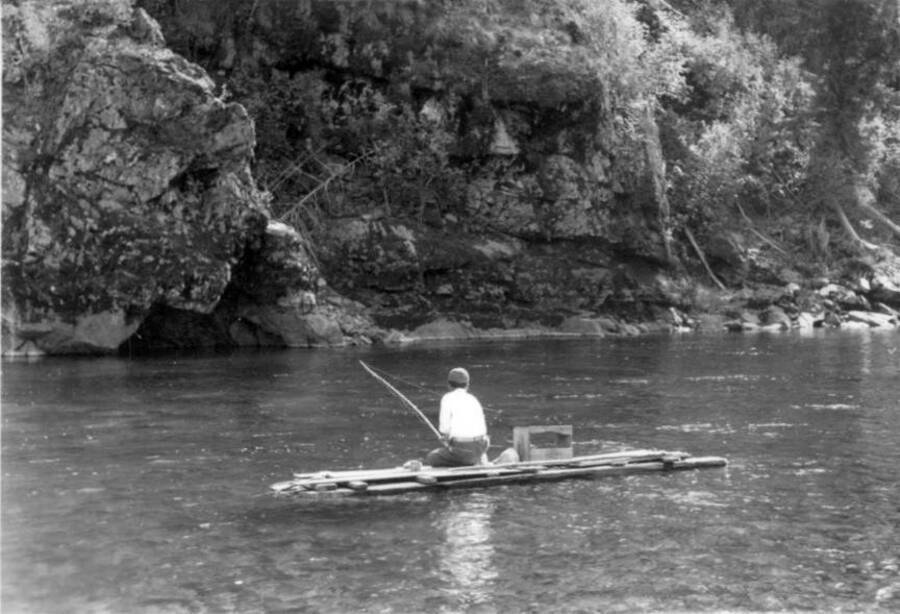 Image of man on raft fishing on the Lochsa River at Kooskia Internment Camp. Photo taken from 12-3/4 x 15-1/4 Photograph album of the Kooskia Japanese Internment Camp.