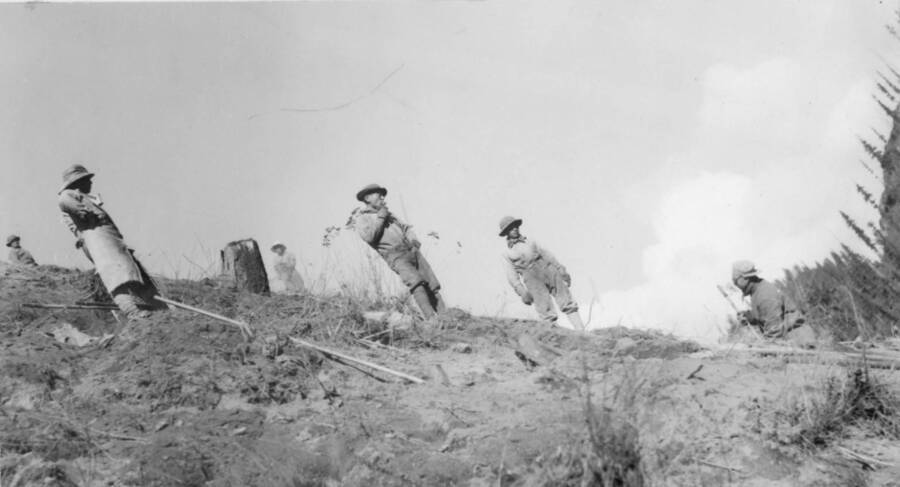 Image of men at construction site standing on a hillside at Kooskia Internment Camp. Photo taken from 12-3/4 x 15-1/4 Photograph album of the Kooskia Japanese Internment Camp.
