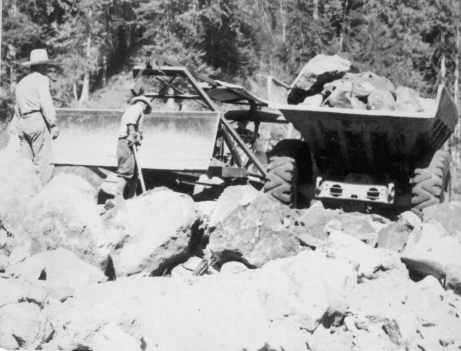 Image of men moving rock with construction equipment at Kooskia Internment Camp. Photo taken from 12-3/4 x 15-1/4 Photograph album of the Kooskia Japanese Internment Camp.