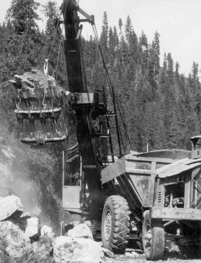 Image of crane and other construction equipment moving dirt at Kooskia Internment Camp. Photo taken from 12-3/4 x 15-1/4 Photograph album of the Kooskia Japanese Internment Camp.