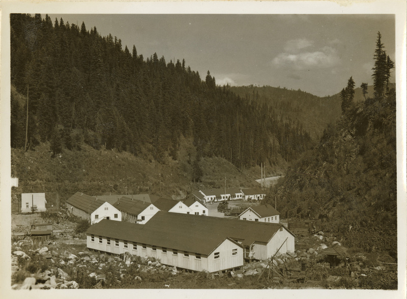 A black and white image of buildings at Kooskia Internment Camp and the mountain-side.