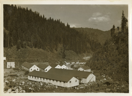 A black and white image of buildings at Kooskia Internment Camp and the mountain-side.