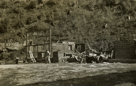 A black and white photograph of a man at a construction site.