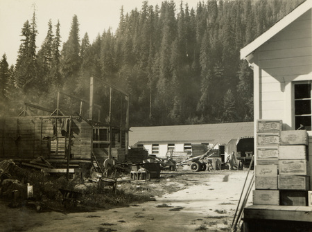 A black and white photograph of men working on construction. There are two other buildings on the right.