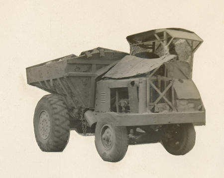 A black and white cutout photograph of a large piece of construction equipment.