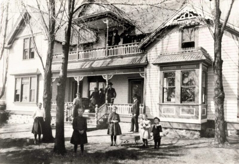 The older Homestead with the bay window can be seen on the right. L-R : Amalia, Martha, Bertha, Viola and Charles. Behind them: Christine on steps, John and Mary on porch and Albert. Upper porch balcony is Bernard and Henry. Photo courtesy of the White Spring Ranch website (by Diane Conroy).