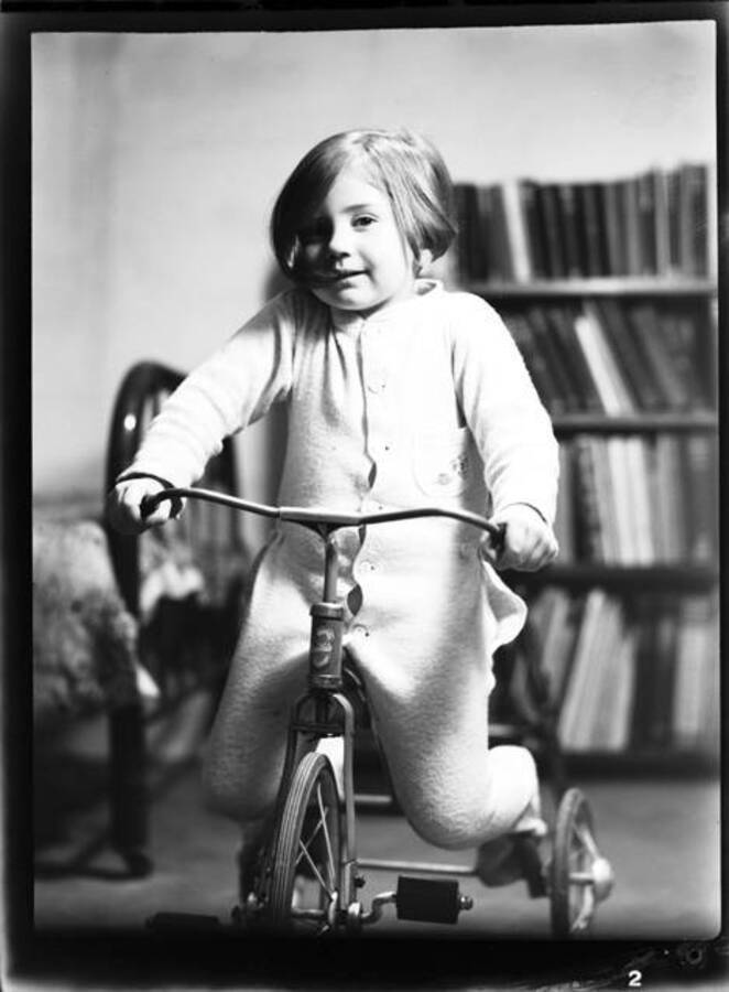 Picture of Kay Laughlin riding a tricycle.