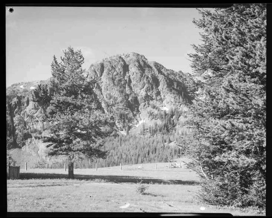 Image show fence, trees and one of the peaks at Seven Devils.