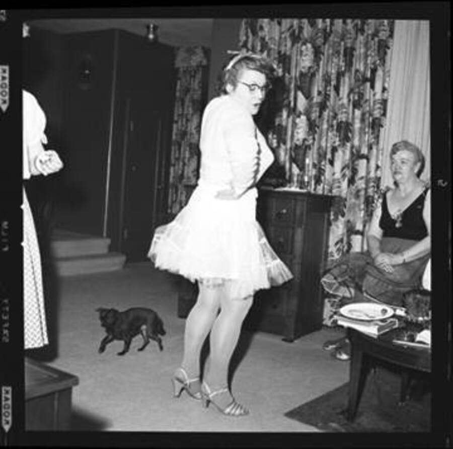 Woman is dancing at a costume party. Jimminy Crickets, the Laughlin family dog, is pictured in the background.