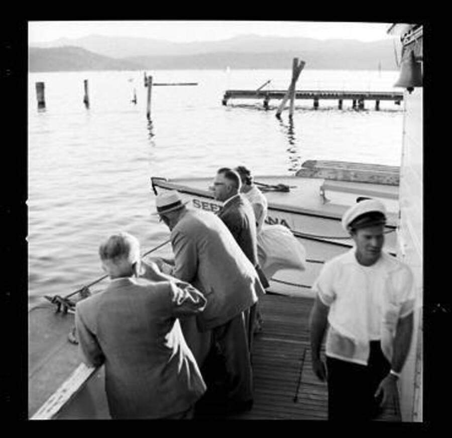 People standing on the boat Dancewana. Dancewana was owned and operated by John Finney on Lake Coeur D'Alene. John Finney is pictured on the right with the white hat.