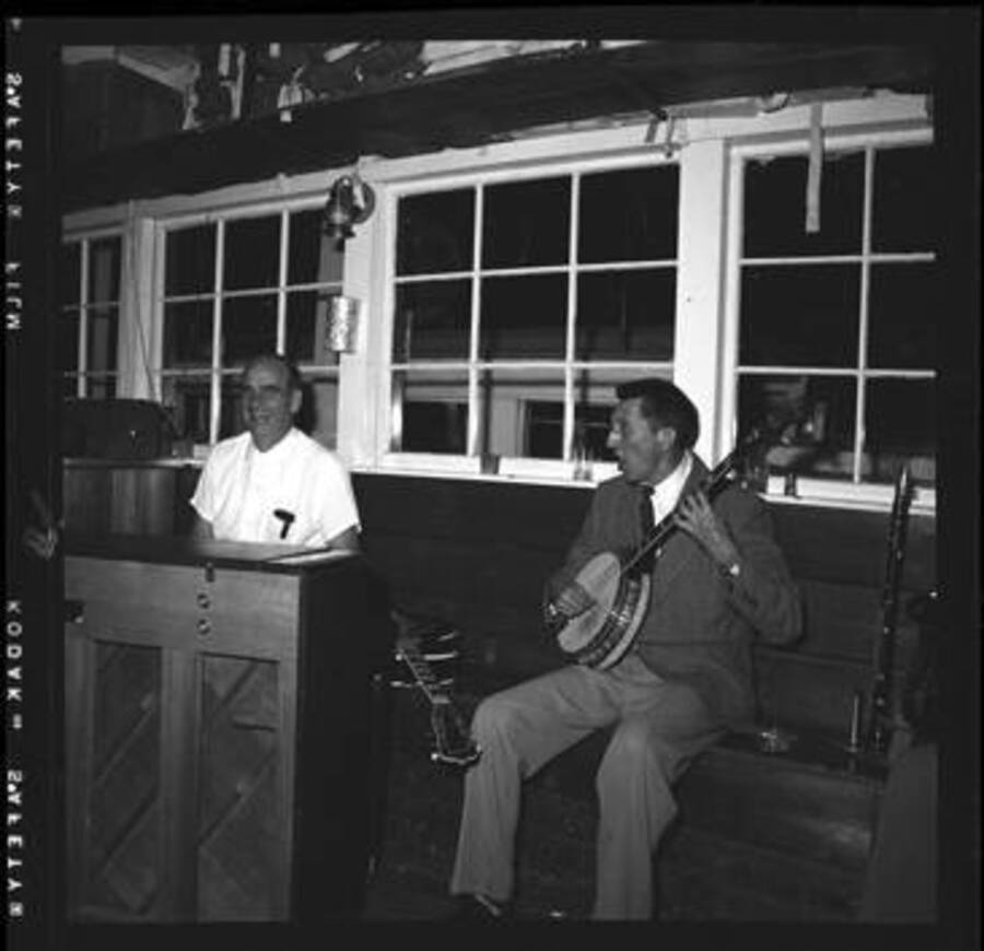 Unidentified persons playing a banjo and piano at a dance at Lake Coeur D'Alene.