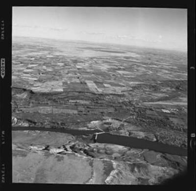 Aerial view not far above upper Salmon Falls Dam. Thousand Springs along bluffs in left foreground.