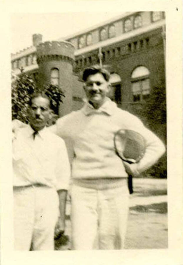 Bert Hopkins and a colleague standing near an academic building in tennis clothing