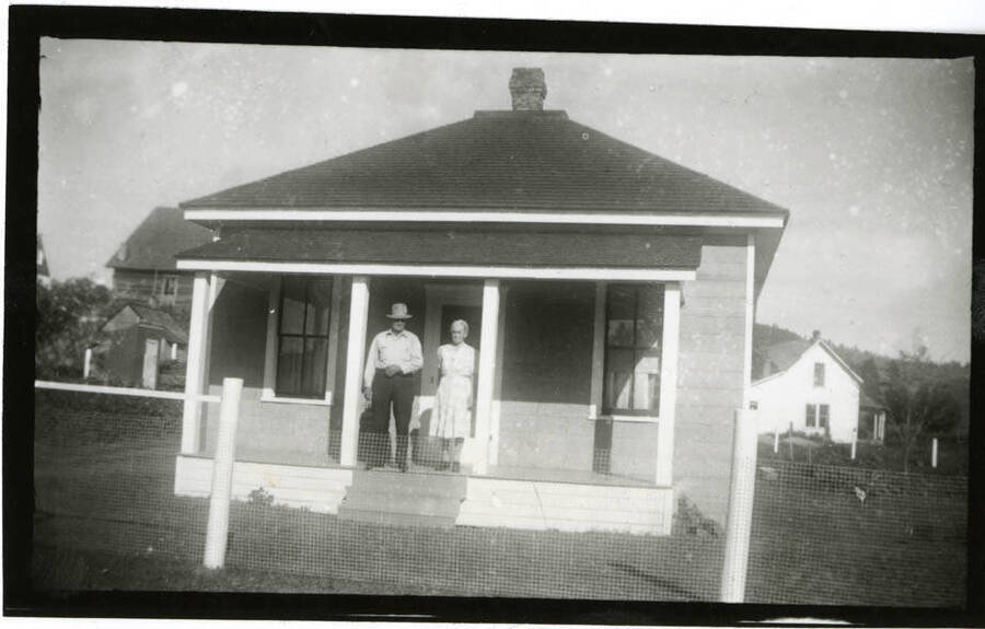 Bill and Minnie Melton standing in front of their home.