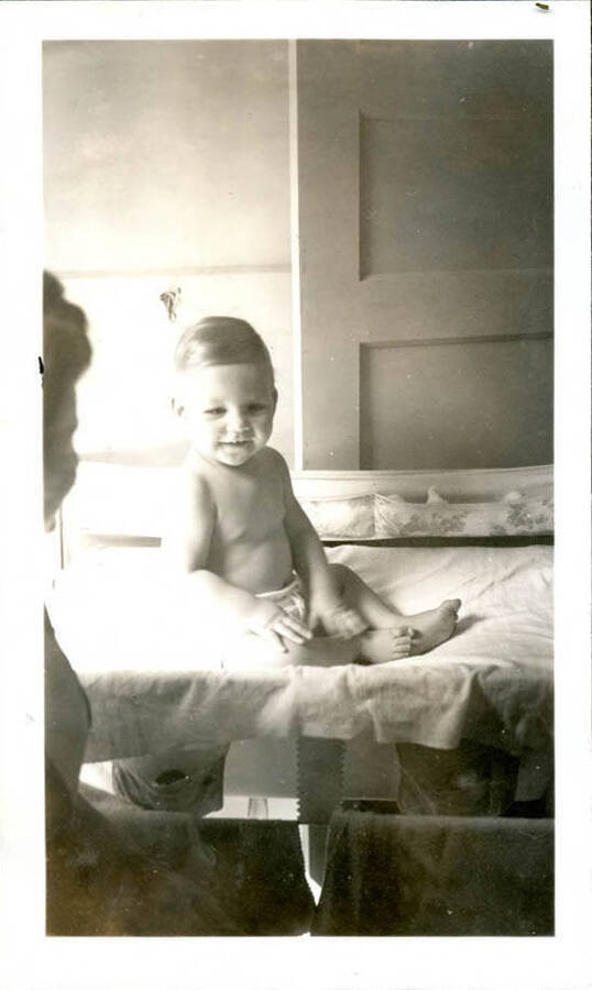 Baby photo of Bill Hopkins, sitting indoors on a changing table