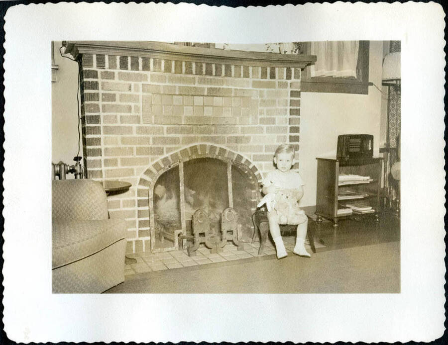 Young Bill Hopkins poses for a Christmas photo in front of a fireplace with a stuffed bunny named Bessie