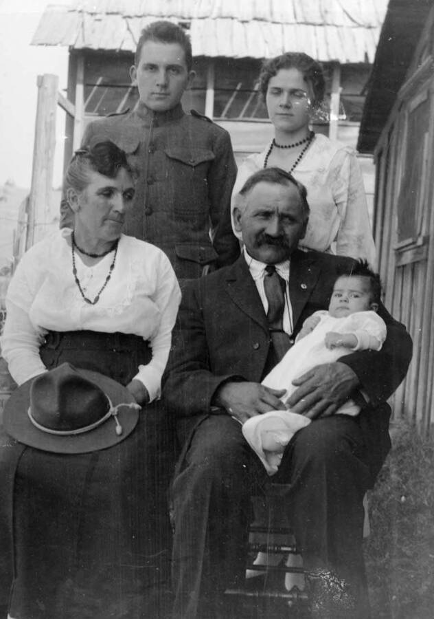 Family portrait of Durrel and Mary Nirk with daughter Clara Anna being held by her grandparents, Bertha Allen Nirk and John Nirk. Standing: Durell and Mary Nirk. Seated: Grandma Bertha Allen Nirk and John Nirk holding granddaughter Clara Anna.