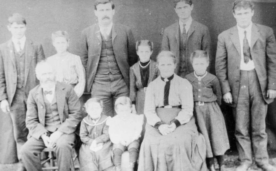Fred Bysegger family portrait. Names read as subjects appear. Front row: Grandpa Fred, Clara, Eddie, Grandma Anna and Ida. Back row: Willie, Emma, John, Mary, Charley, and Fred.