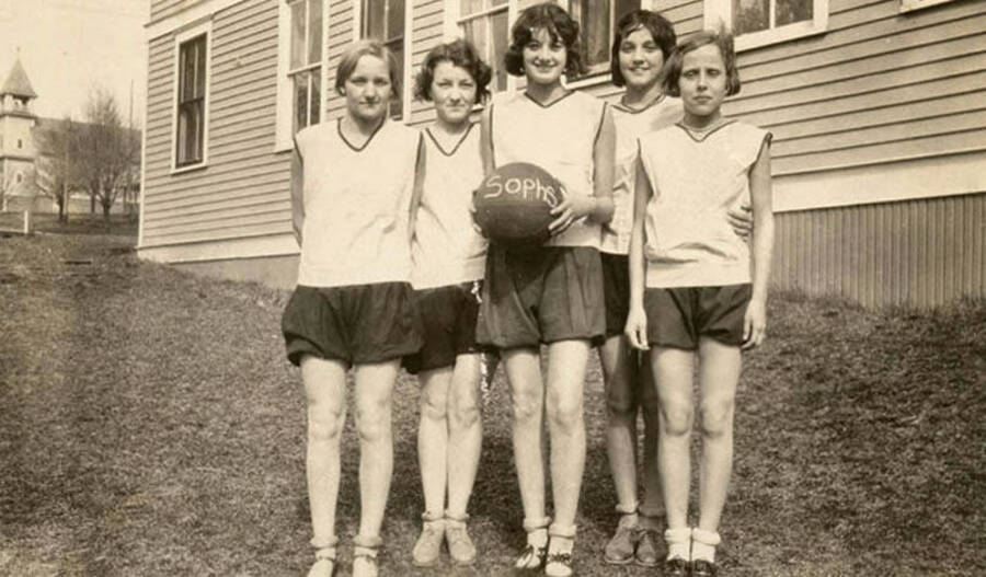 Photograph of the Potlatch sophomore girl's basketball team posing in front of the elementary school, basketball in hand. From left to right: Alene Schultz, Beulah Piper, Bertha Beyer, Alene Puckett, Thelma Vasser, and Louise Katzenberger.