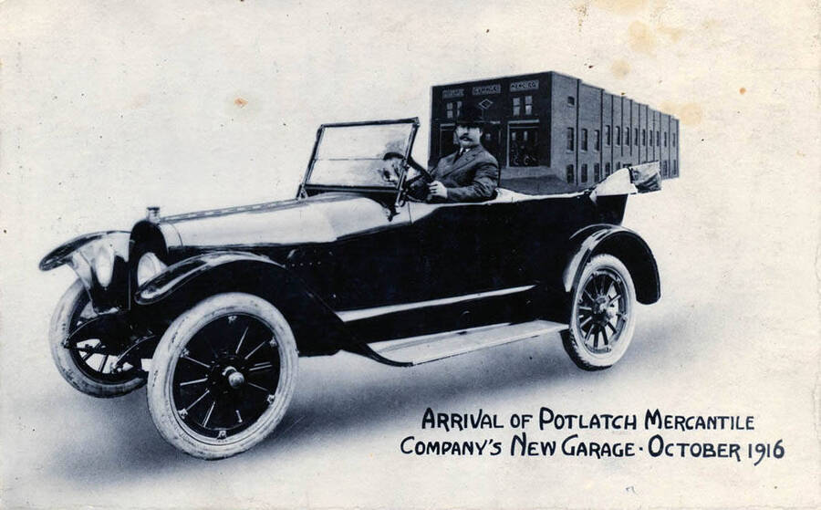 Postcard of the arrival of Potlatch Mercantile Company's new garage. A.A. McDonald is pictured inside a new Mitchell car.