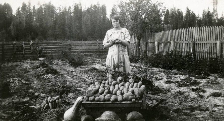 Ida Soncarty stands behind a wheelbarrow full of tubers and squash in her garden at the Soncarty farm.