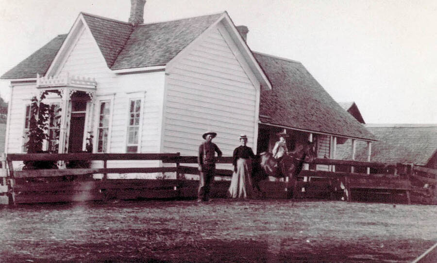 The Andy Smith family standing outside a house. The child can be seen sitting on a horse. The home later became the Waddell Place.