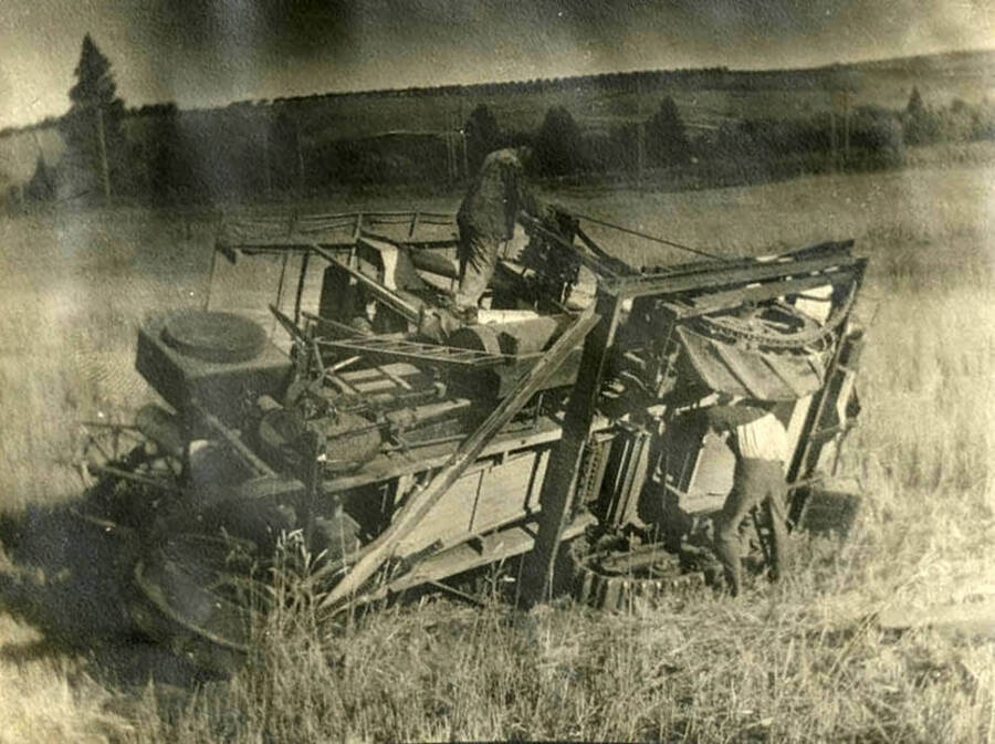 Robert W. McKown stands atop his self-propelling combine after it fell onto its side.