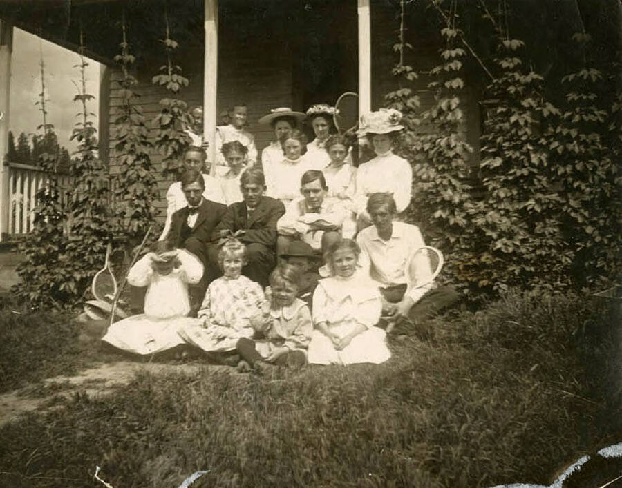 The clark family gathered together to celebrate Vern's twenty-first birthday outside an unknown house. Vern is seated in the second row from the front, the second person from the left.